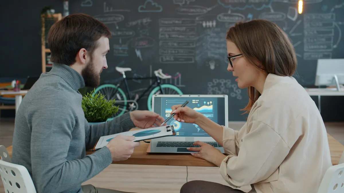 Colleagues reviewing business data on a laptop