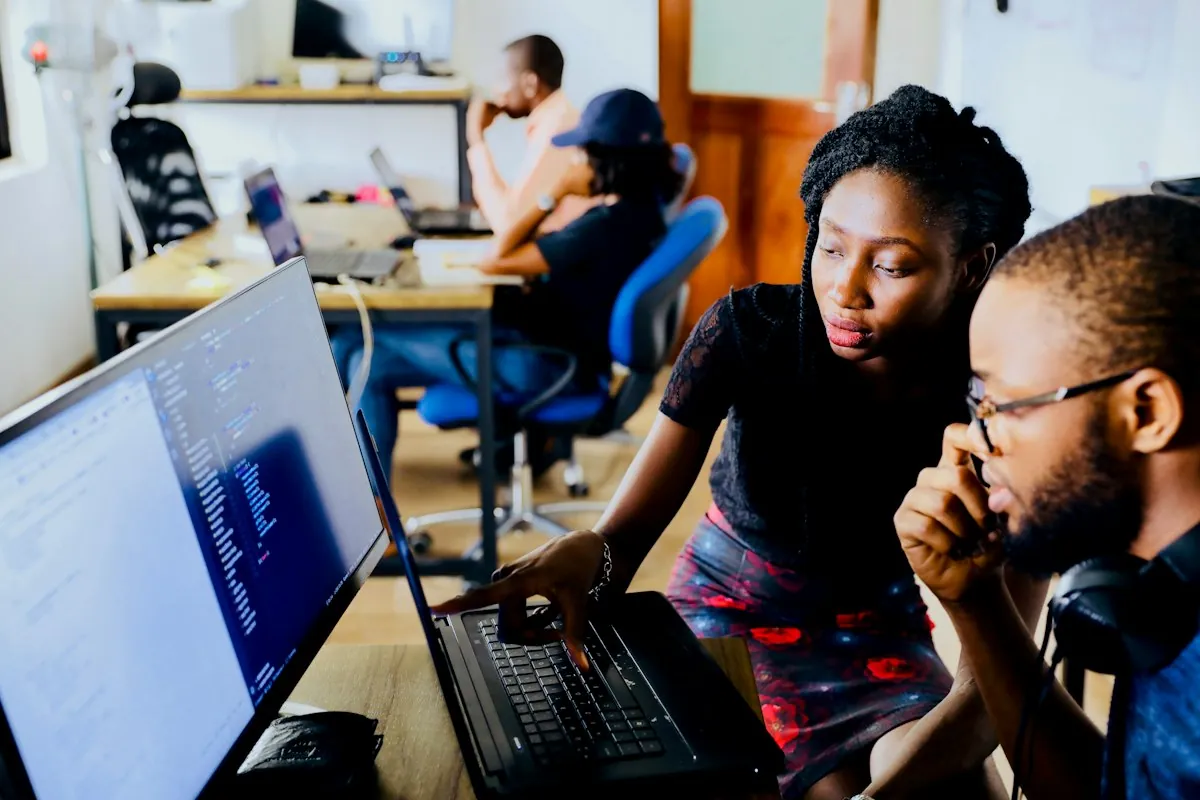 Two colleagues working through a request at a computer