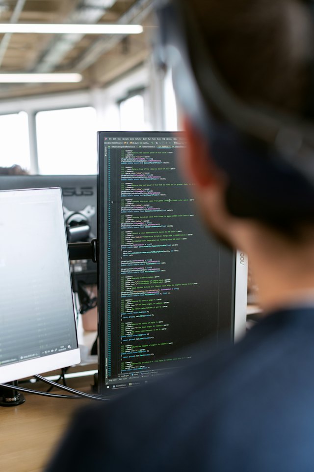 Desarrollador trabajando con código en varios monitores
