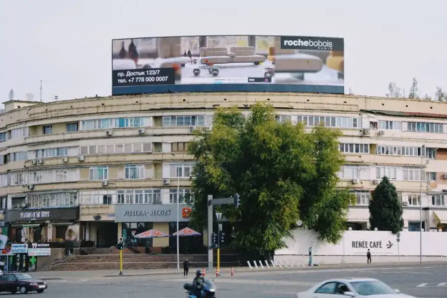 Un edificio redondo con una valla grande en su fachada