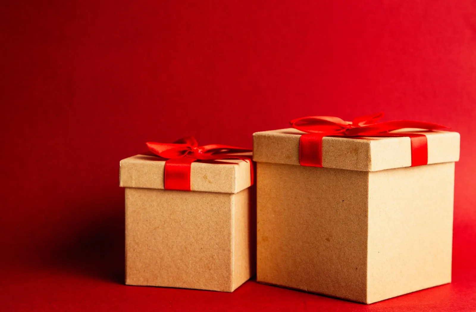 Cajas de regalo con lazos rojos sobre un fondo rojo