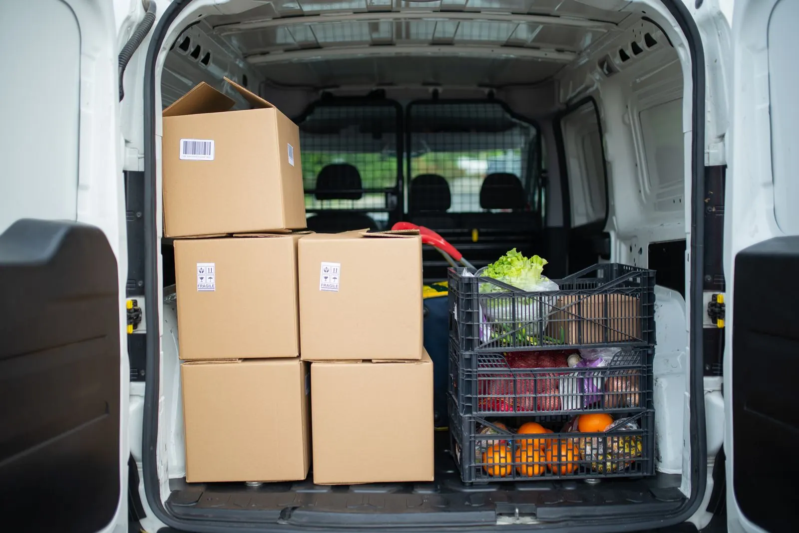 Una camioneta de reparto cargada con cajas y productos frescos