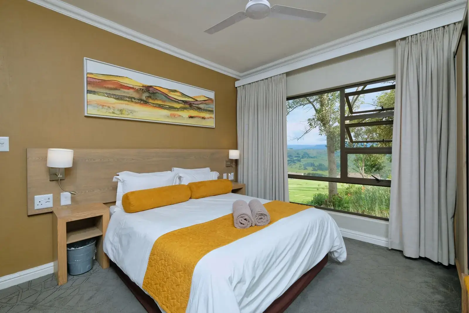 Una habitación con la cama hecha y una ventana con vista