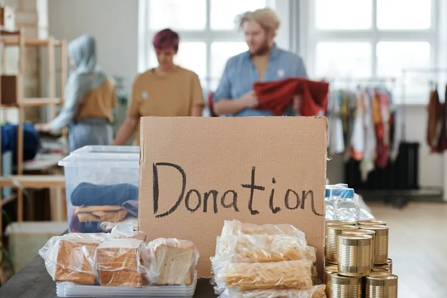 Voluntarios clasificando ropa y alimentos en un centro de donaciones
